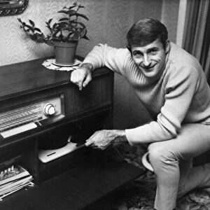 Liverpool footballer Roger Hunt listening to music at home. Circa 1966