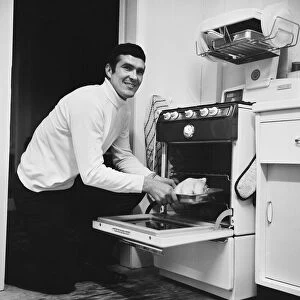 Liverpool footballer Ron Yeats poses at home with his new gas cooker