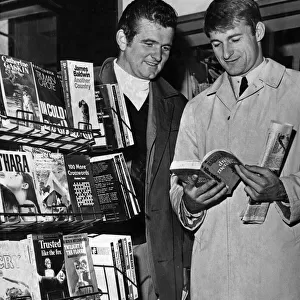 Liverpool footballers Tommy Lawrence and Roger Hunt looking through books at a stall in
