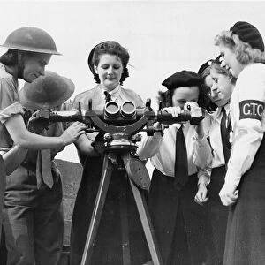Liverpool members of the Girls Training Corps displaying a keen interest in an instrument