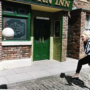 Liz Dawn Actress plays Vera in Coronation Street as she practices for a charity football