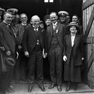 Während Lloyd George lachend herzhaft über einen Witz mit dem geächteten Dichter (an seiner rechten Seite, neben ihm), Herr