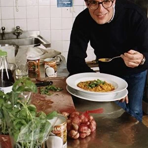 Lloyd Grossman TV Presenter of Master Chef in his wn kitchen trying out his own cooking