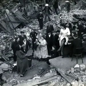 Locals dancing around the piano down Bow way, London. Blitz