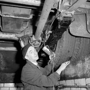 London Transport mechanics seen here checking the tyres of a Leyland bus London Transport mechanics seen here checking the tyres of a Leyland bus