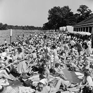 Londons Hyde Park Lido. A crowd a of sunbathers by the Serpentine