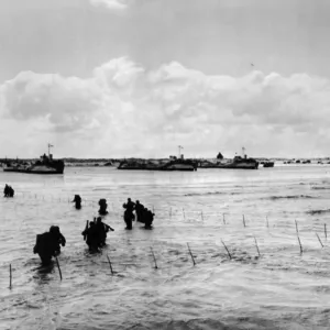 A long line of U.s army men wade through shallow water off northern coast of France to A long line of U.s army men wade through shallow water off northern coast of France to