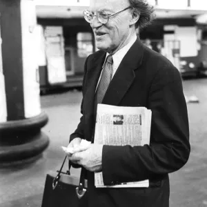 Lord Frank Longford carrying copy of tabloid newspaper at Euston station
