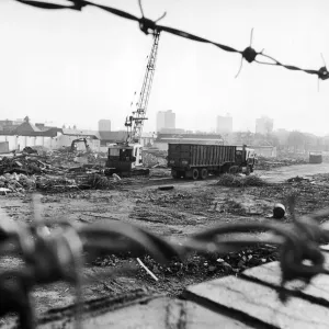 Lorries wait to take away the rubble which is all that remains of the former eight storey