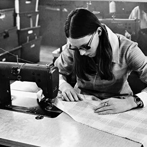 Machinist Lynn brown sews pockets onto a skirt during her shift at a textiles factory