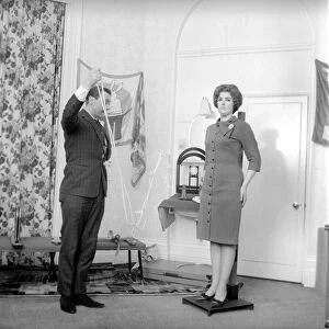 Magician Bernard Hughes performing rope trick with female assistant