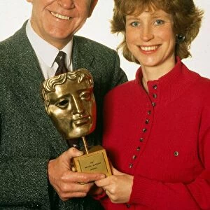Magnus Magnusson with daughter Sally, holding a BAFTA award. March 1990
