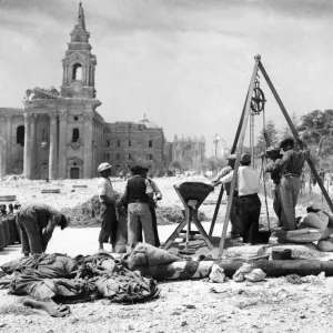 Maltese workmen hauling and measuring grain from one of the underground granaries in Maltese workmen hauling and measuring grain from one of the underground granaries in