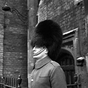 A man of the Coldstream Guards on duty outside Buckingham Palace wearing the traditional