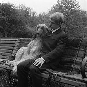 Man and dog sitting on park bench circa 1970