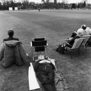 A man falls asleep on the boundary of the first cricket match of the season between A man falls asleep on the boundary of the first cricket match of the season between