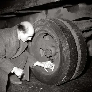 A man helps a kitten who was trapped in lorry wheel January 1950