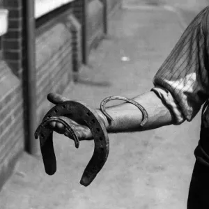 A man holding various horseshoes. 1st June 1922 A man holding various horseshoes. 1st June 1922