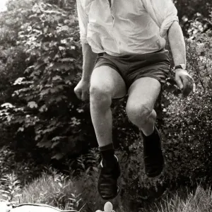 A man leaping over mans face holding an egg in mouth January 1974 A man leaping over mans face holding an egg in mouth January 1974