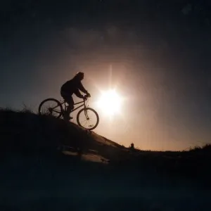 A man riding his mountain bike cross country A man riding his mountain bike cross country