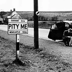 A Man trying to repair a punctured tyre outside the Hamlet of PITY ME in Durham county