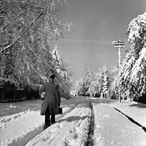 Man walks along a road covered in deep snow in Tadworth. April 1950 O23770-006