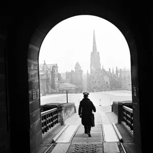 A man who helps operate the Time Gun walking through the entrance archway to Edinburgh A man who helps operate the Time Gun walking through the entrance archway to Edinburgh