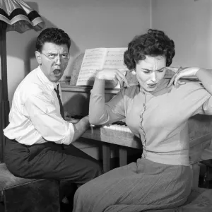 Man, Woman, Singing: Wife puts her fingers in her ears to block out her husband Man, Woman, Singing: Wife puts her fingers in her ears to block out her husband