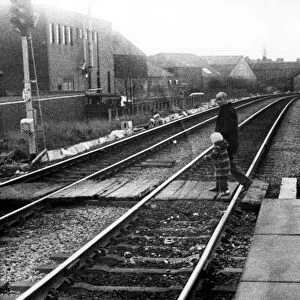A man with a young child illegally crossing the railway line at West Jesmond Station