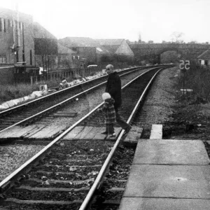 A man with a young child illegally crossing the railway line at West Jesmond Station A man with a young child illegally crossing the railway line at West Jesmond Station