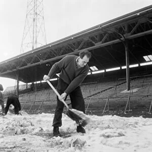 Manager Joe Harvey and players, clear snow from pitch at St James Park