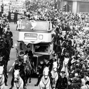 Manchester City footballers parade the FA Cup trophy to fans lining the streets of