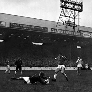 Manchester City goalkeeper Bert Trautmann dives and saves at the feet of Dawson of