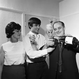 Il calciatore del Manchester United George Best con occhio nero tenendo una bottiglia di champagne mentre egli.