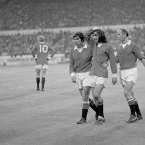 Manchester United footballer George Best is consoled by teammates Tony Dunne (left