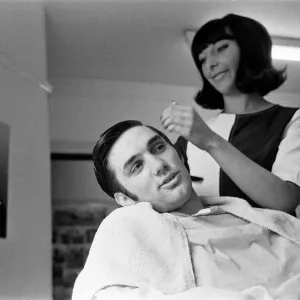 Le joueur de football du Manchester United, George Best, a ses cheveux coupés par Lynda Cole.