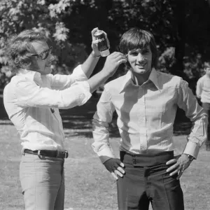 Manchester United footballer George Best has hair spray applied by his personal