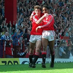 Manchester United footballer Mark Hugfhes celebrates a goal with teammate Paul Ince at