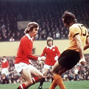 Manchester United footballer Sammy McIlroy battles for the the ball with Derek Dougan