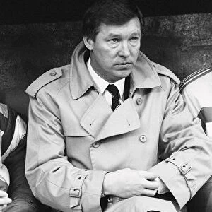 Manchester United manager Alex Ferguson checks his watch in the dugout during the League