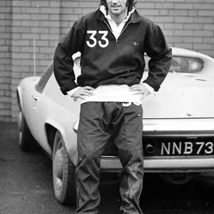 El estrella del Manchester United George Best se posa junto a su coche Lotus Europa después de una sesión de entrenamiento. El estrella del Manchester United George Best se posa junto a su coche Lotus Europa después de una sesión de entrenamiento.