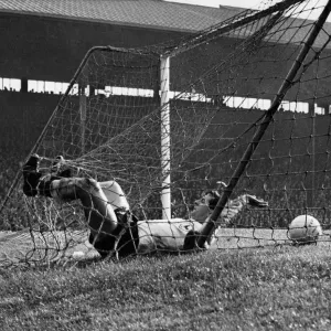 Manchester United v Tottenham. The Spurs half back Mullery ands up in the net after a Manchester United v Tottenham. The Spurs half back Mullery ands up in the net after a