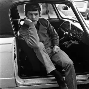 Manchester United's Brian Kidd listening to the FA Cup draw on his car radio Print