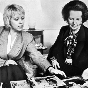 Margaret Thatcher looking over photographs with official - May 1987