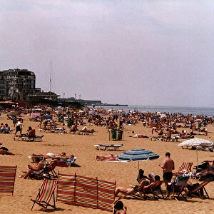 Margate Beach with tourists and daytrippers sunbathing. People sitting on deck chairs