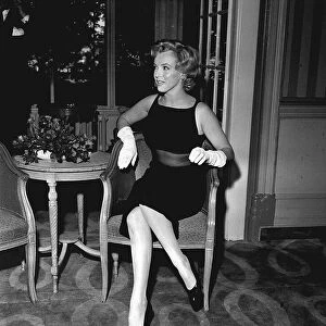 Marilyn Monroe sitting on a chair in her hotel foyer for Mirror Feature by Donal Zec