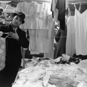 A market trader modelling ladies underwear to gain a sales in Kingston Market circa 1936 A market trader modelling ladies underwear to gain a sales in Kingston Market circa 1936
