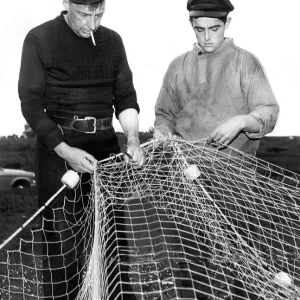 Matthew Stanton and Henry Rowe repairing their fishing net in whcih a whale became Matthew Stanton and Henry Rowe repairing their fishing net in whcih a whale became