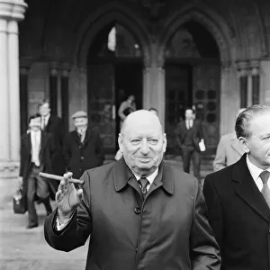 Media Mogul Lew Grade poses outside the High Court in London, smoking one of his cigars