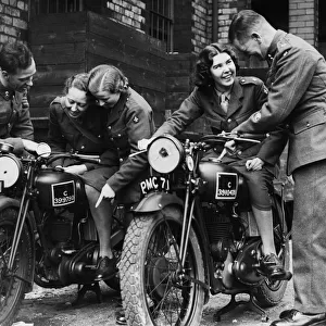 Members of the W. A. T.s learn a little about motorcycling from soldier at a Manchester
